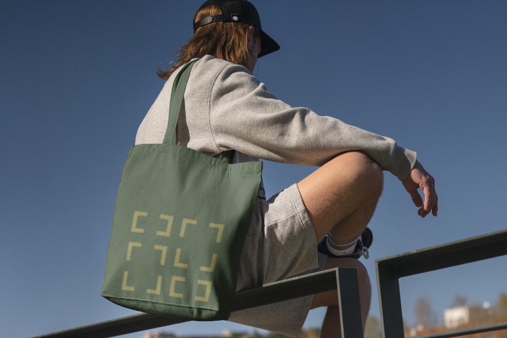 Green Ionize Studios tote bag with geometric logo pattern