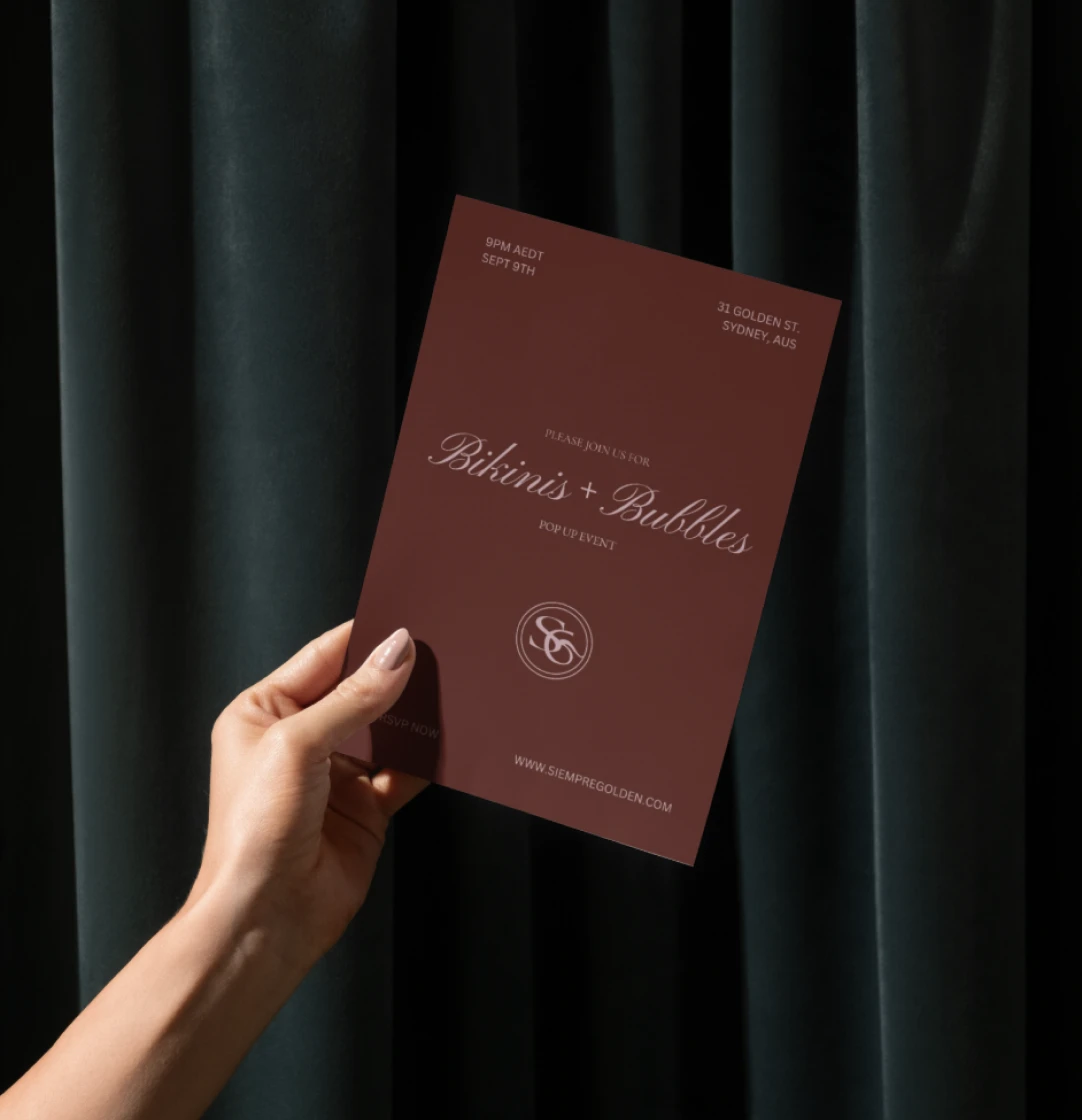 Hand holding a Siempre Golden brand invitation card